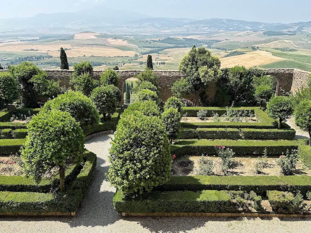 Gardens of Palazzo Piccolomini with views of the Val d'Orcia in the background.