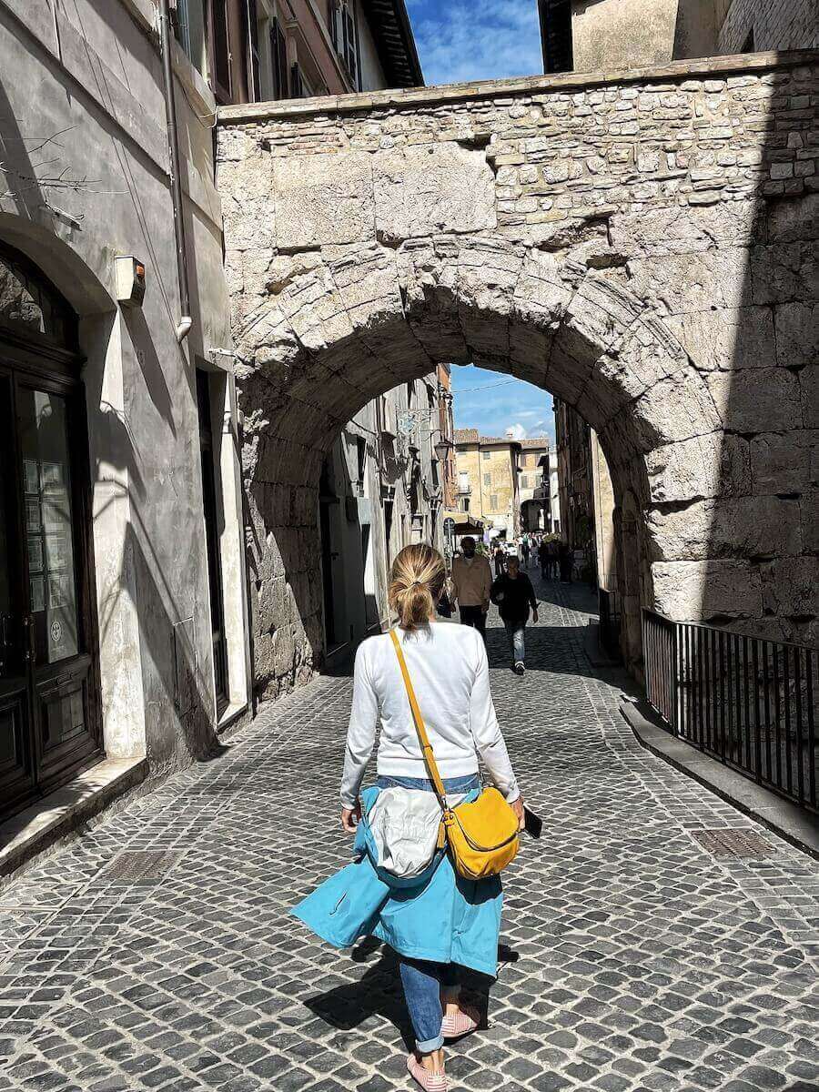 Walking through the Arch of Drusus in Spoleto.